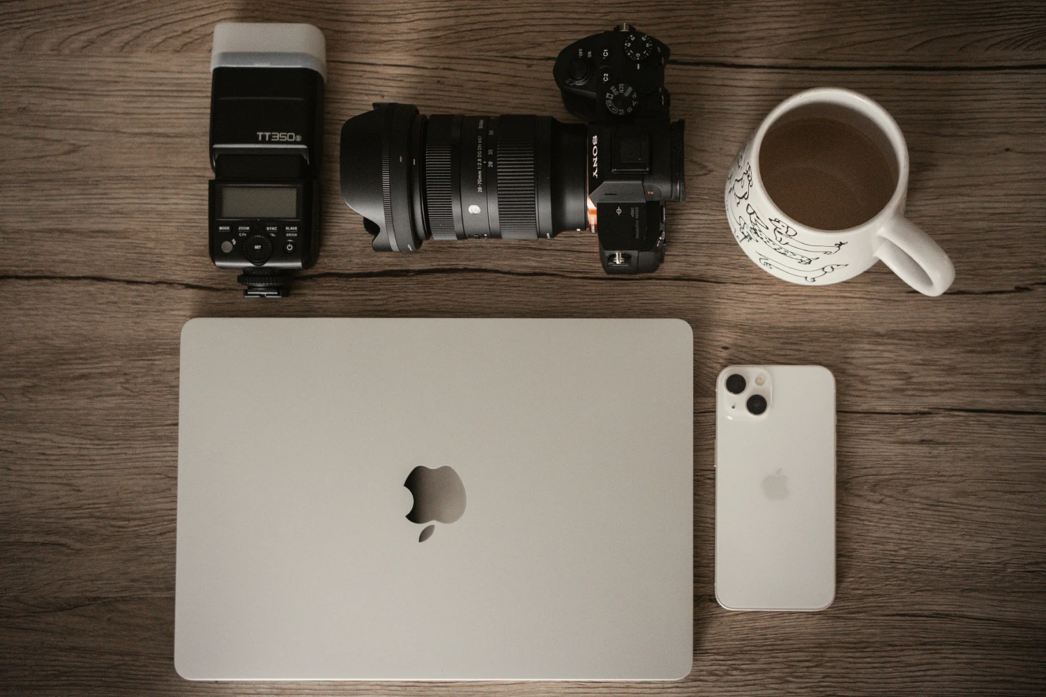 Mesa con cámara, portátil, móvil y café: el punto de partida del briefing