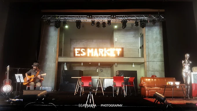 Actuación acústica en un pequeño escenario decorado con neón