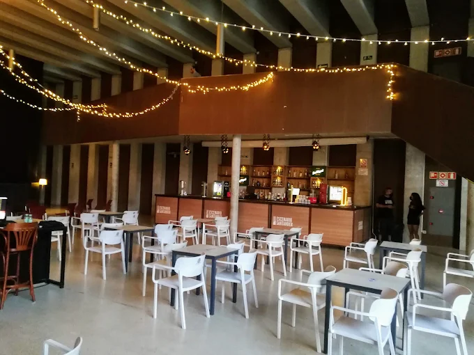 Zona de barra y mesas con luces cálidas en Escenario Santander